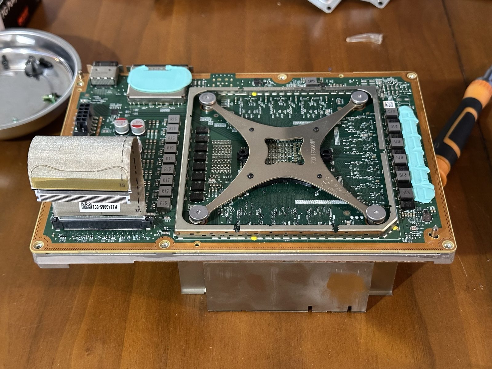 The X clamp, four spring-loaded screws visible at its corners